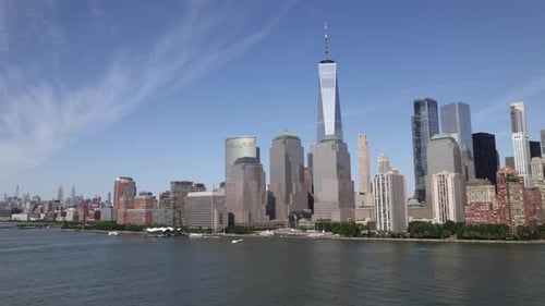 Aerial view revealing a ferry driving towards the Manhattan cityscape, in NYC, USA