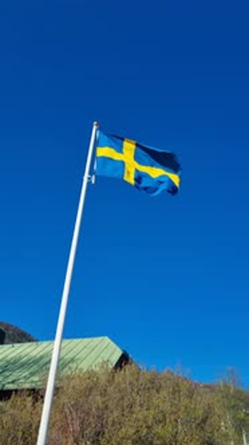 Swedish Flag Waving Proudly Against Clear Blue Sky