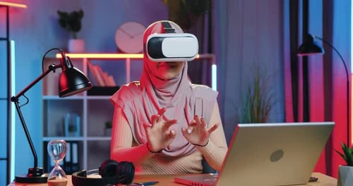 Young Adult in VR Headset in Neon Lit Room