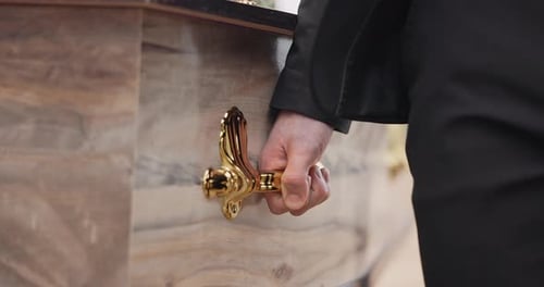 Coffin, hands and pallbearer walking at cemetery ceremony outdoor at tomb