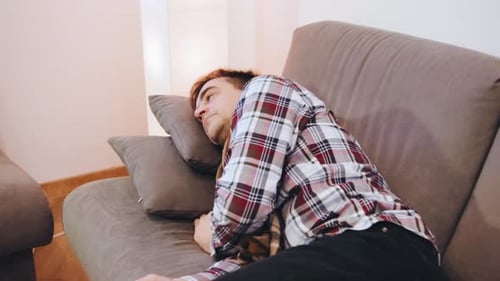 An Elderly Sick Man in a Scarf and a Plaid Shirt Tired Falls on the Pillows to Rest and Overcome the