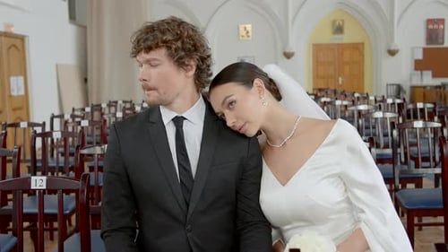 The Groom and His Bride in the Temple ActionA Beautiful Young Couple in Wedding Costumes are Sitting