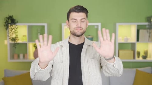 Young man making no, stop, no gestures towards the camera with his hands and gestures.
