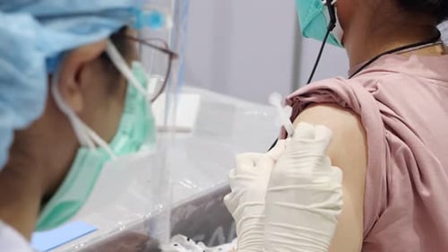 Asian Medical Staff Give Vaccination Shot, Close Up