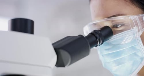 Female Scientist Using Microscope in Laboratory