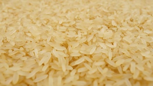 Closeup View of Uncooked White Rice Grains on a Flat Surface