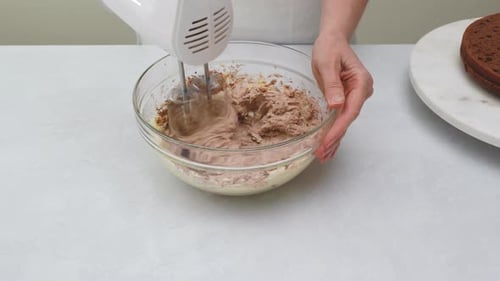 Woman Mixes Chocolate Frosting with Electric Mixer