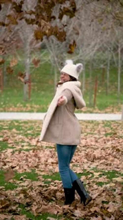 Woman Plays with Leaves in the Autumn