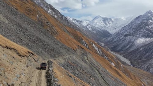 Vehicle Navigating Rugged Mountain Terrain with Dramatic Landscape Views