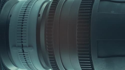 Cinematic vertical Close up shot of a 35mm metal cinema lens with a lens cover, manual aperture, cam