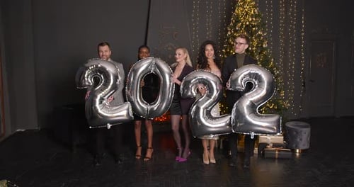 Young Adults Celebrate New Year with Balloons