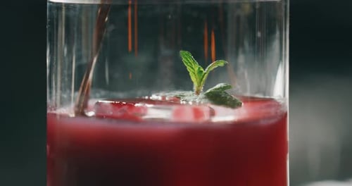 Stirring Refreshing Red Drink with Mint and Ice