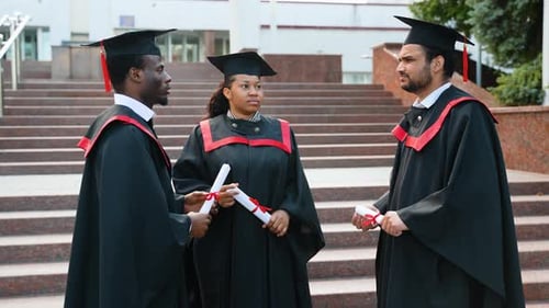 College Graduates in Cap and Gown Talking