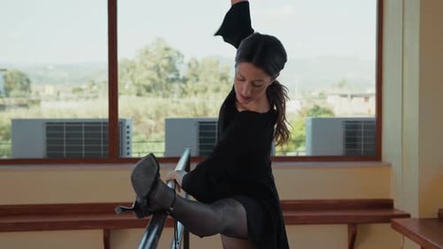 Elegant Woman Stretching Leg on Barre
