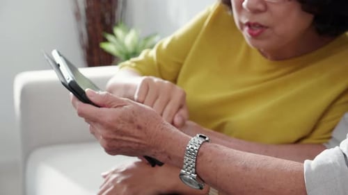 Senior Women Using Tablet Together in Living Room