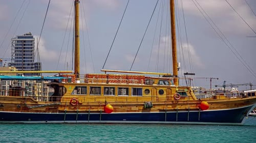 A Colourful Fishing Boat At The Harbor Sailing In By The Coastal City In Malta