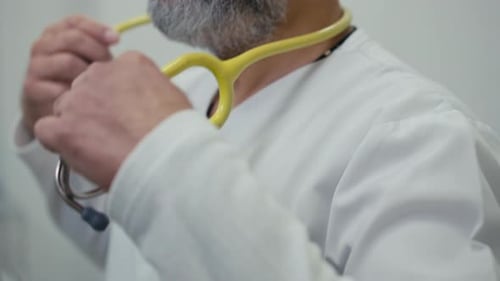 Doctor Putting On Stethoscope in Medical Environment
