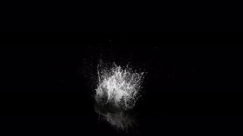 Abyss Collection: A large splash above the surface of water falling very slowly over a black backgro