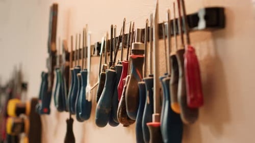 Chisels Screwdrivers Wrench and Pliers on Wall in Furniture Assembly Shop