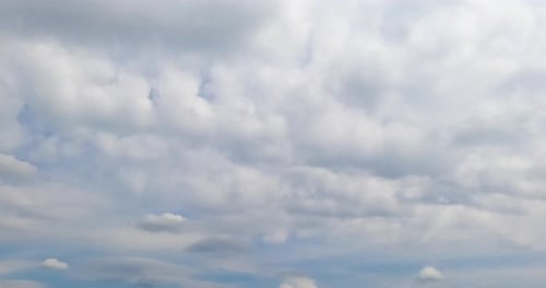 White clouds spreading along the horizon. Cloudscape in the sky on rainy daytime. Timelapse.