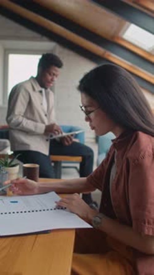 Diverse Colleagues Discussing Data in Presentation in Loft Office