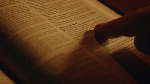 Person Reading Book in Dim Light