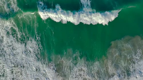 Aerial View Of Foamy Waves Rolling On Beach In Slow Motion