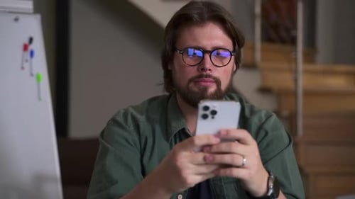 Businessman or Coach Using Smartphone and Resting From Work Sitting at Table in Home Office Spbas