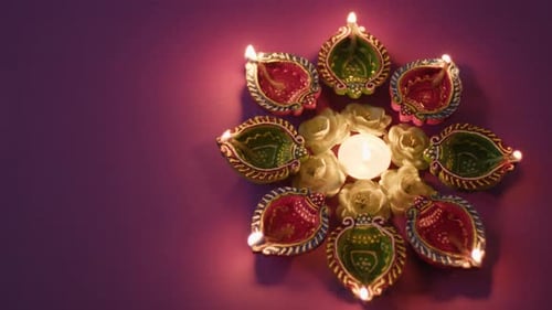 Lighting Candle Among Diyas and Flowers for Diwali