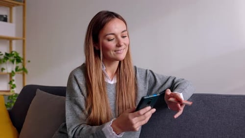 Happy Female Customer Using Smartphone for Online Payment