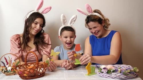 Family Wearing Bunny Ears Crafting Easter Decorations
