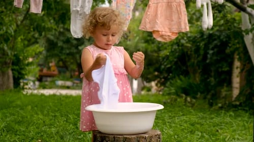 The Child is Washing Clothes in the Garden Selective Focus