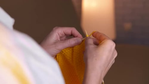 Woman Knitting Yellow Wool Yarn at Home