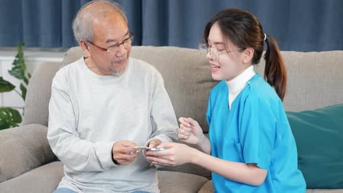 Woman Nurse Caregiver Show Prescription Drug to Senior Man at Nursing Home