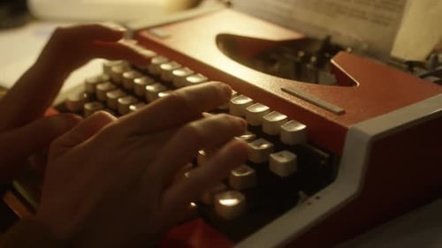 Hands Type on a Red Vintage Typewriter