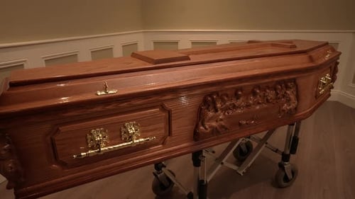 Ornate Wooden Casket with Religious Carvings Indoors