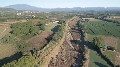 Luftbilder über einem trockenen Fluss neben Feldfrüchten in Spanien Katalonien