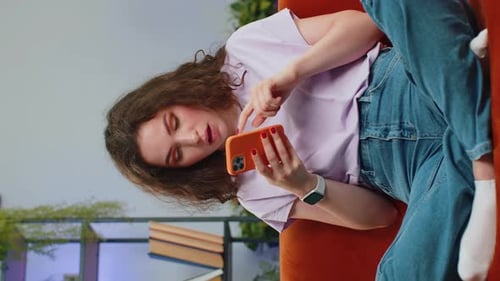 Woman Frustrated Using Smartphone on Sofa