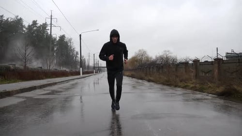 Strong Athlete in Sportswear Jogging Along Trail at Cloudy Day Young Sportsman Running Along Asphalt