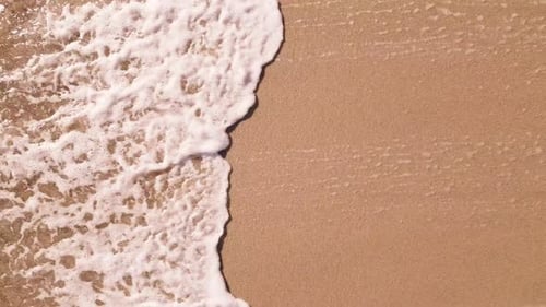 Aerial Top Down View on a Sandy Beach with Sea Surf Slow Motion Nobody