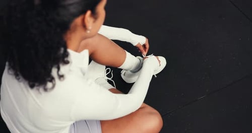 Above, woman and tie shoes in gym for fitness, run or start exercise routine with laces for health