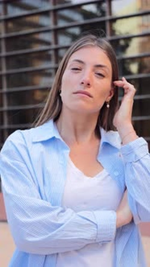 Confident Young Woman Poses in Front of Building