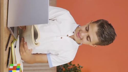 Vertical video of Boy reading a book.