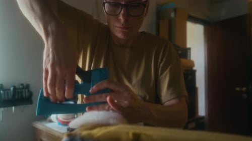 Person Using Staple Gun to Upholster Furniture
