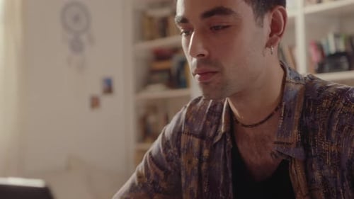 Young Adult Typing on Laptop at Home