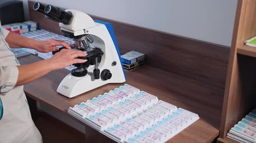 Doctor during biochemical analysis. Drop of samples between two microscope slides