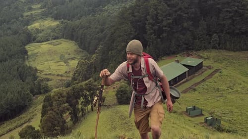 Trekker Walking Away From Log Cabin to Go Hiking in Green