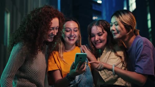 Friends Gathered Together Looking at Smartphone in City