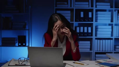 Businesswoman seriously stressed working overtime headache and eye ache due to office syndrome