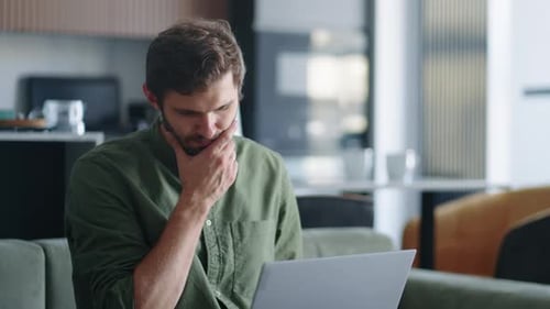 Penssive Man está trabajando con una computadora portátil en casa por la noche, escribiendo un mensaje en el chat en línea y trabajando en